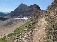 View of Timpanogos Saddle (upper right) with Mount Timpanogos (center). Timpanogos Basin falls away to the north (left) and the Emerald Basin shelter is just visible if you follow the snowline to the left in the photo. The left-most peak is Robert's Horn.